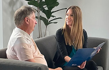 Man talking to person at the resource center sitting on a couch