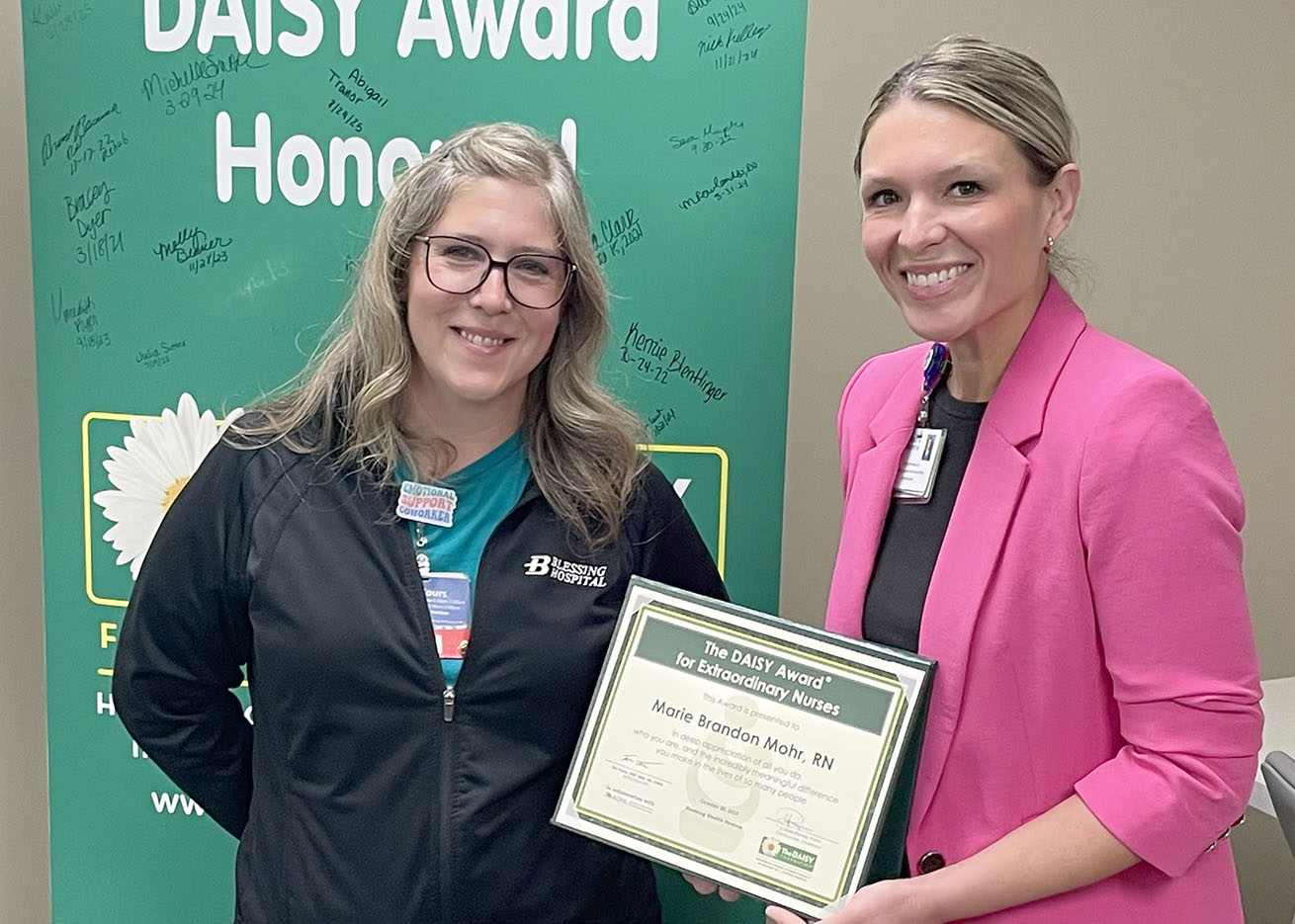 : Marie Mohr, RN, (left) accepts her DAISY Award from Ambulatory Associate Chief Nursing Officer, Jamie Kane.