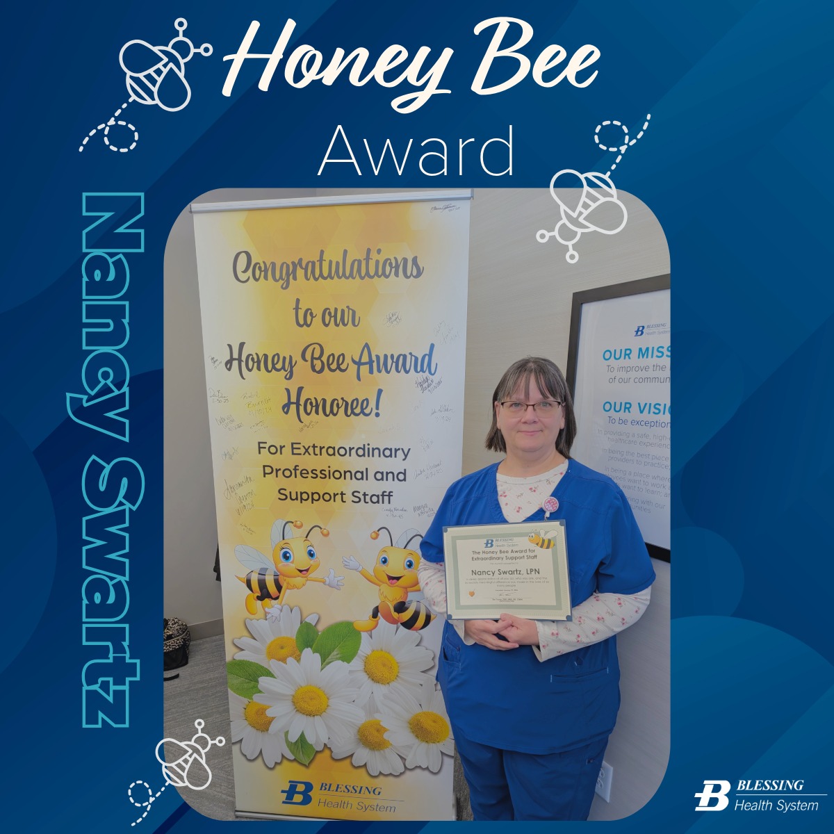 Nancy Swartz holds her Honey Bee award certificate in front of the Honey Bee banner