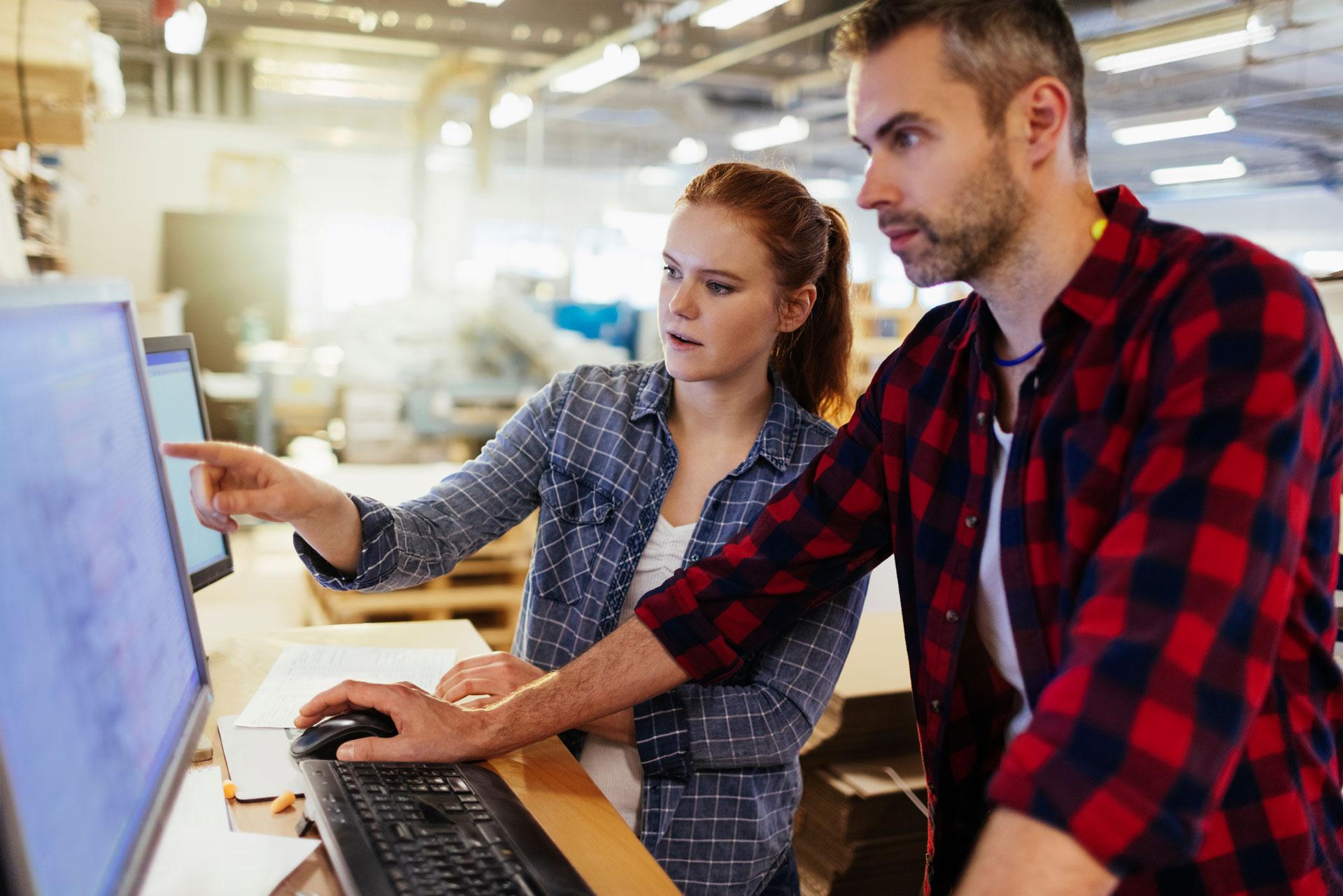 man and woman looking at computer